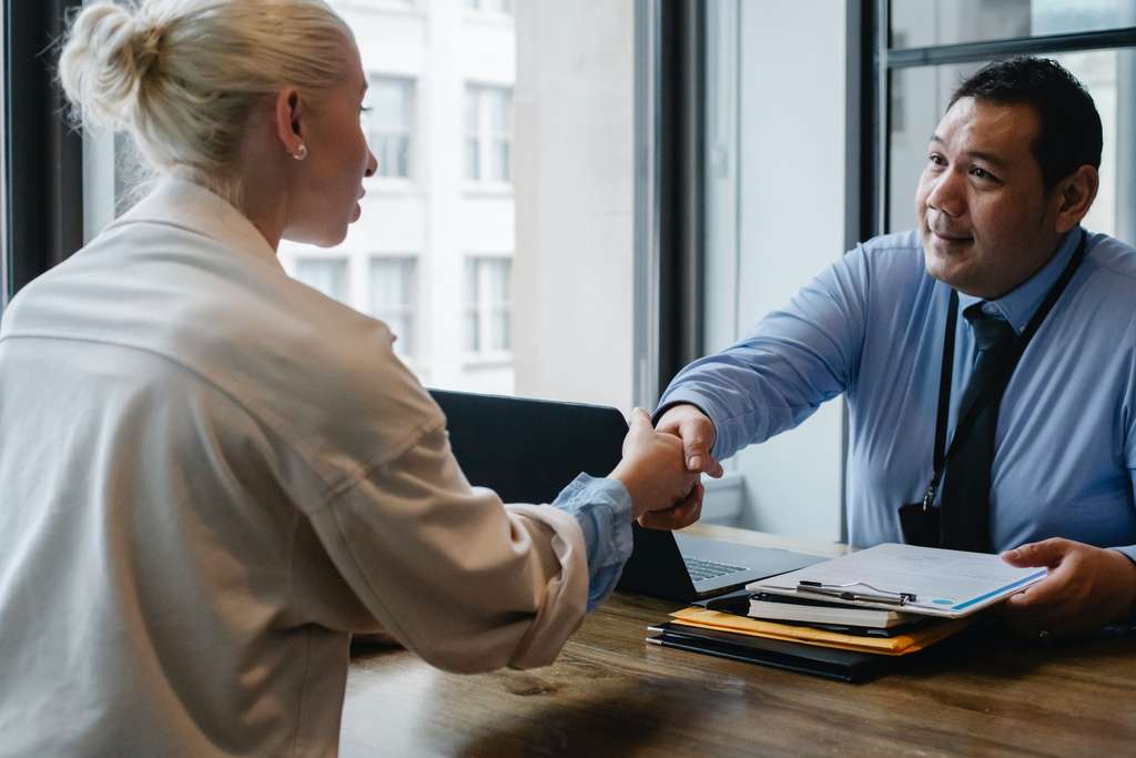 male employer and female employee shaking hands