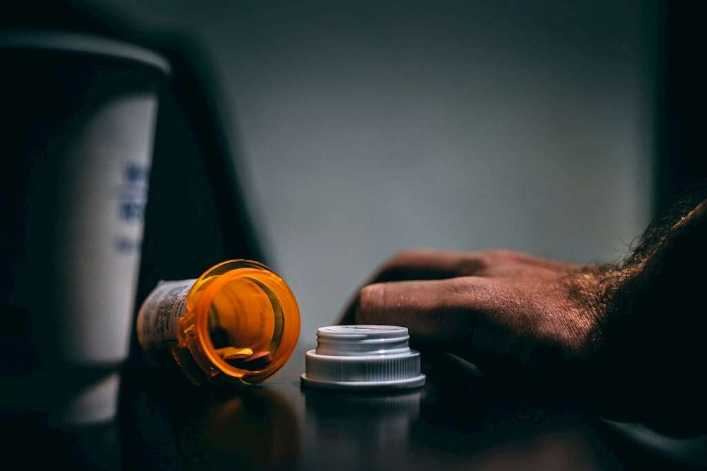 hand and pill bottle