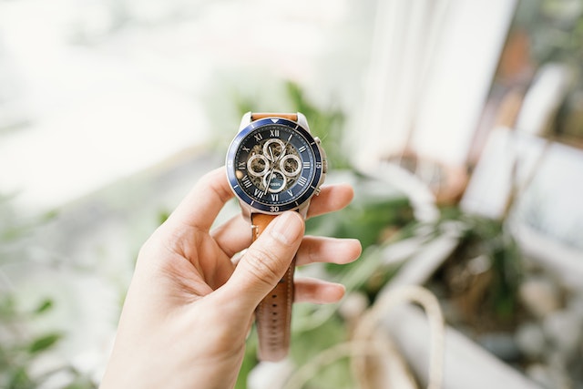 hand holding a brown watch