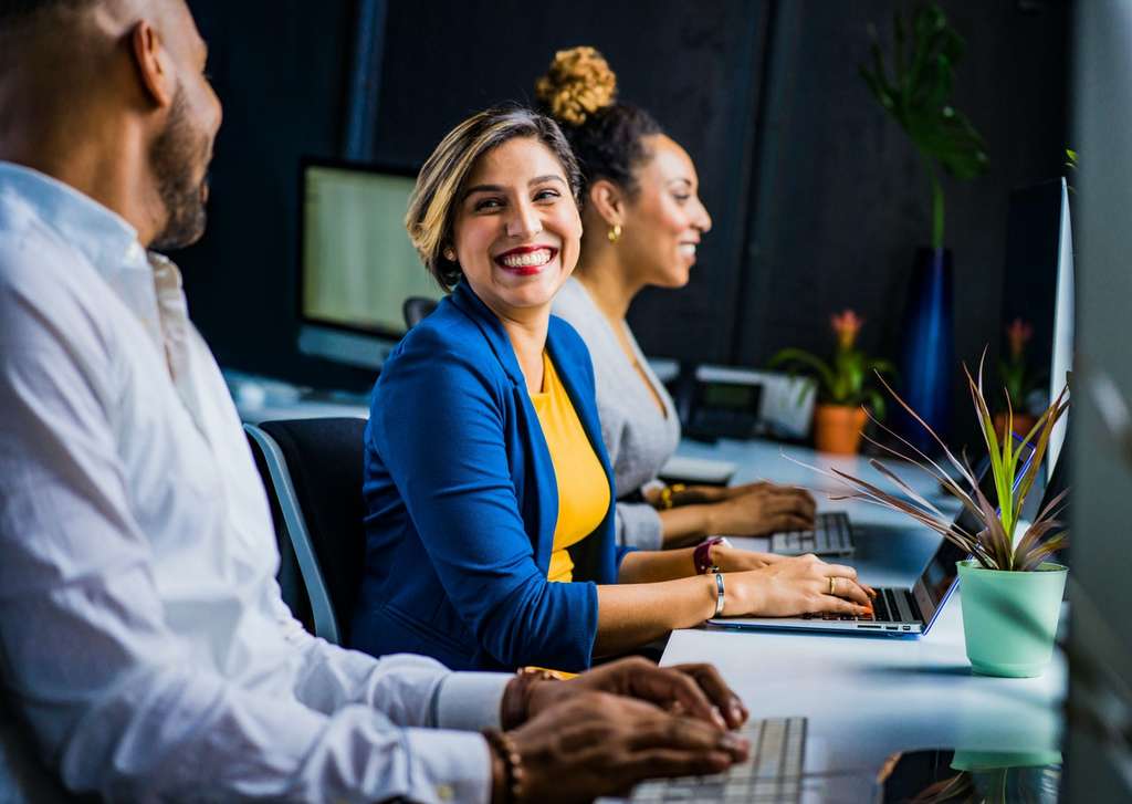 men and women smiling at work