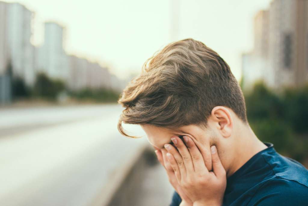 Person rubbing face with hands