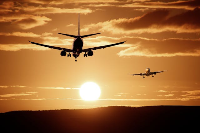 Two planes flying at sunset