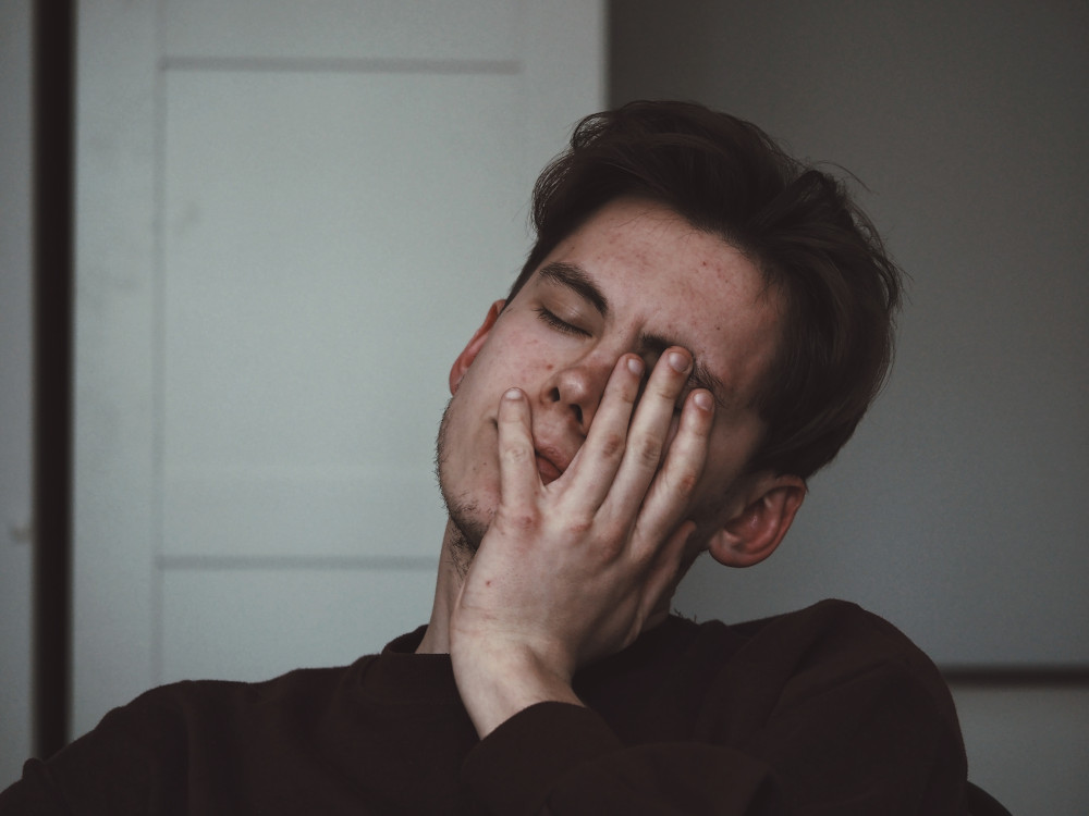 Man rubbing his face with his hand