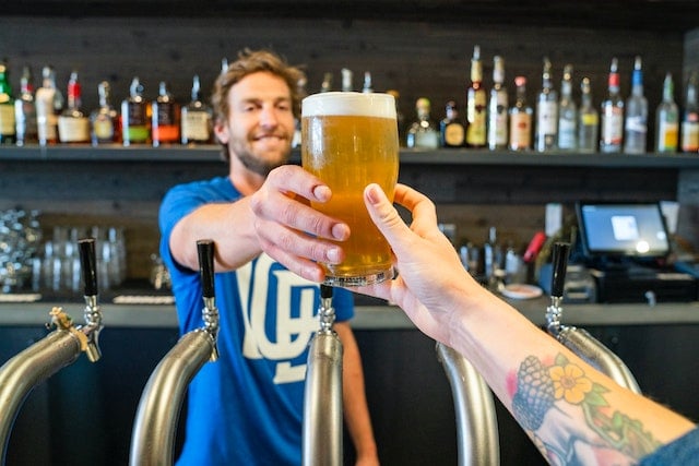 bartender handing customer beer