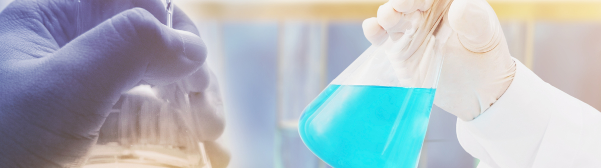 gloved hands holding glass beakers