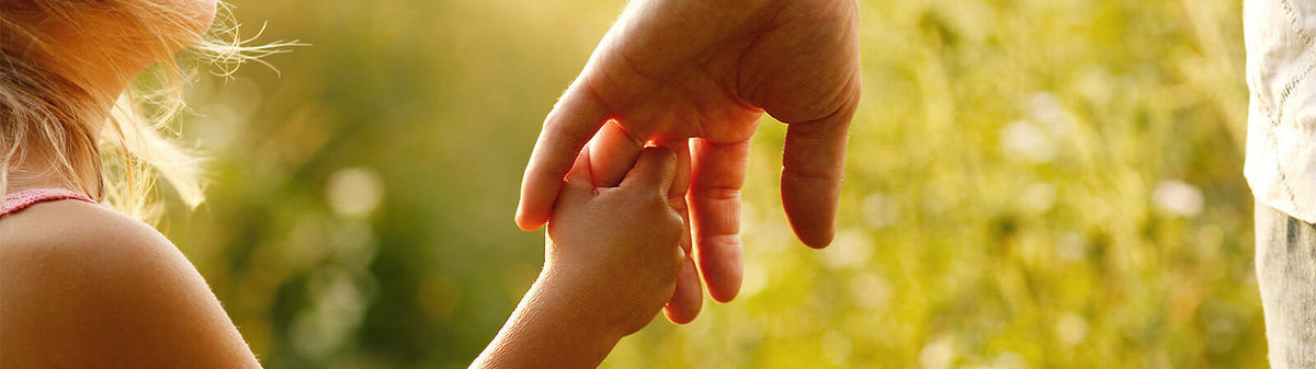 Young girl holding fathers hand