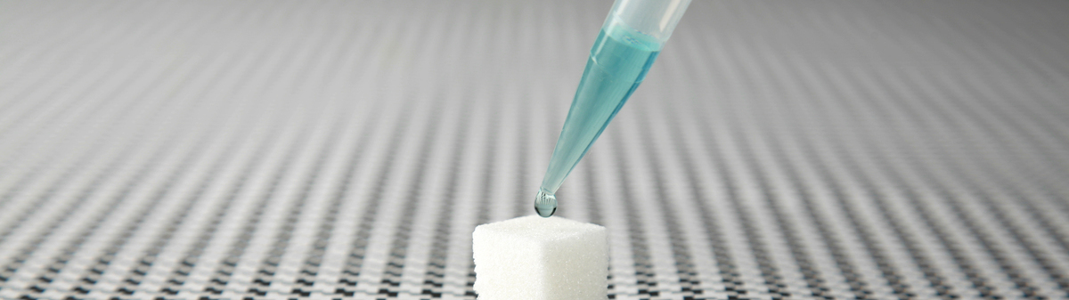 eye dropper putting blue liquid on white cube