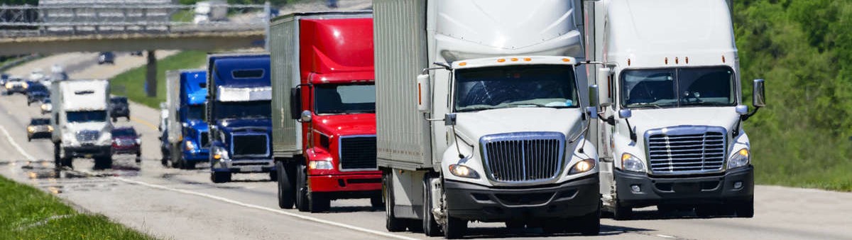 A group of semi-trucks on the highway