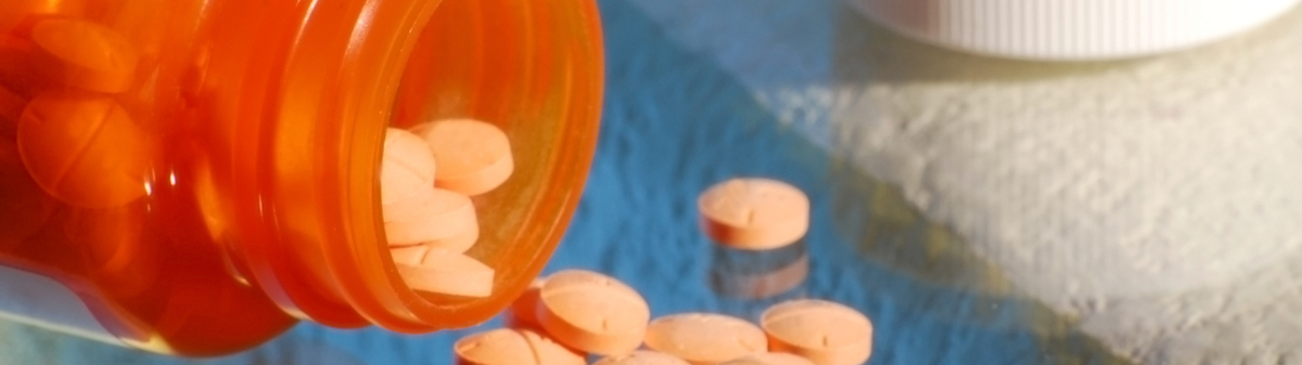 Orange bottle spilling out orange pills