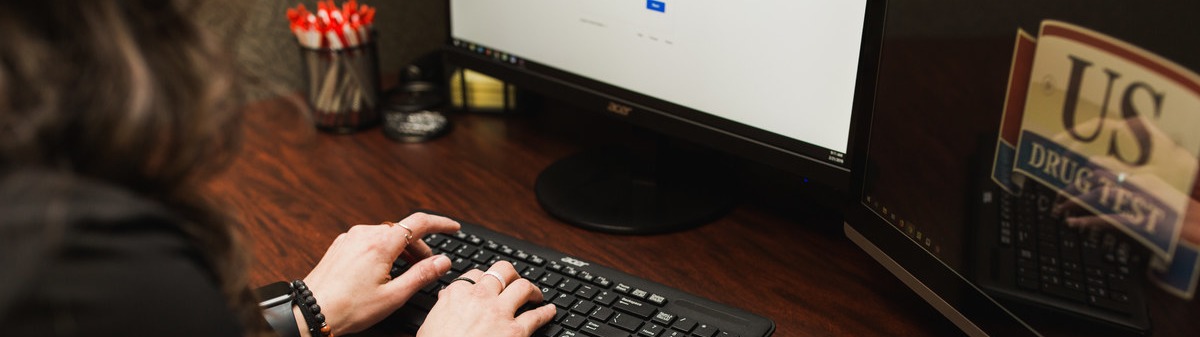 Woman typing on desktop computer