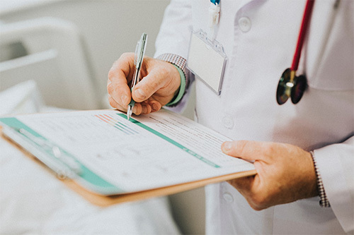 doctor writing on clipboard