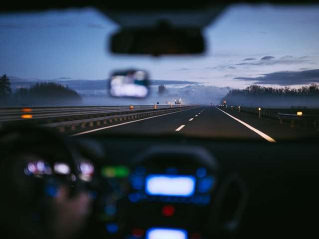 The view of an empty highway from the backseat of a car