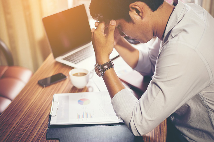 man sitting at his desk looking at charts