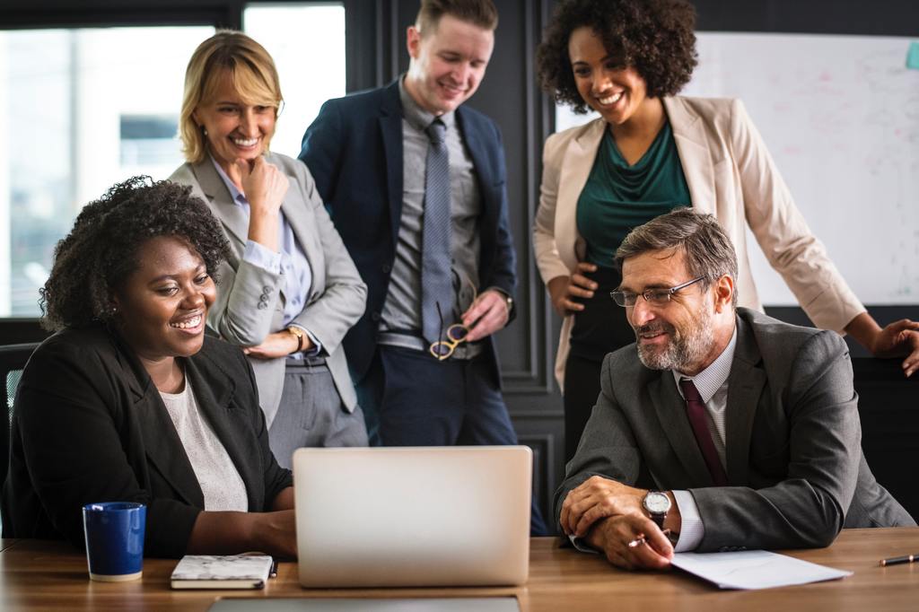 employees gathered around a laptop