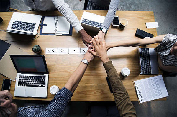 employees putting hands in