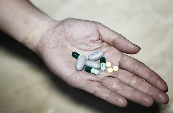 woman holding handful of pills