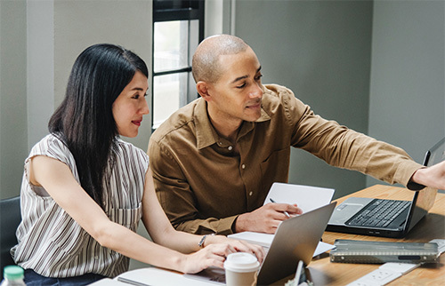 man and woman working at computer