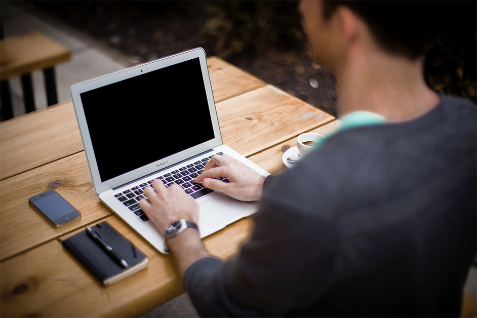 man typing on a laptop