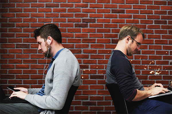 two men working on laptops