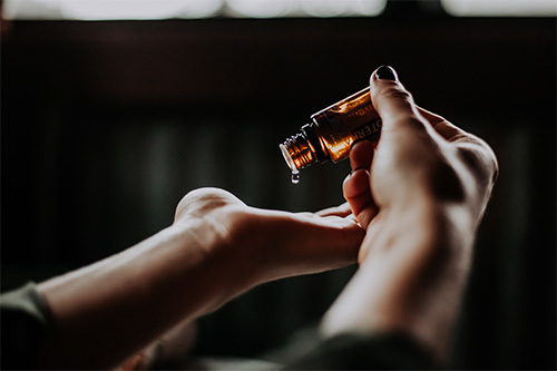 person holding bottle of oil