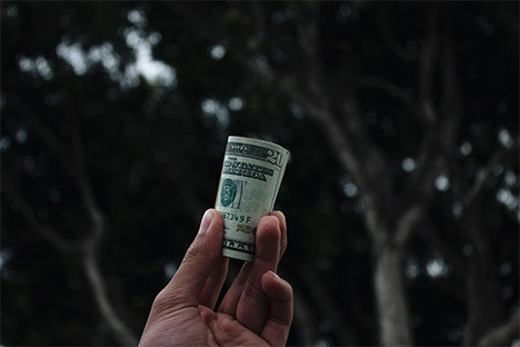 person holding roll of cash