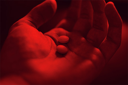 person holding two pills