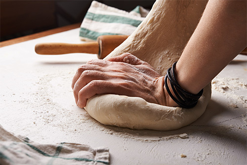 person kneading dough