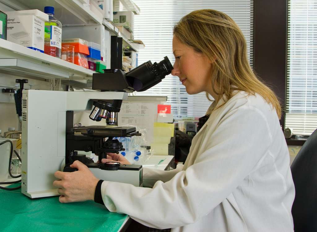 A female scientist looking through a microscope