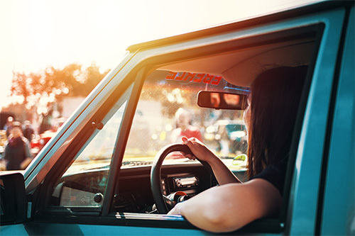 teenager driving blue car