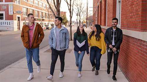 teenagers walking down sidewalk