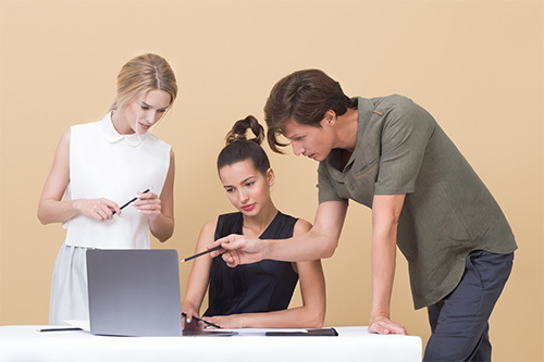 three employees working at computer