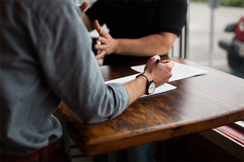 two people sitting at wood table