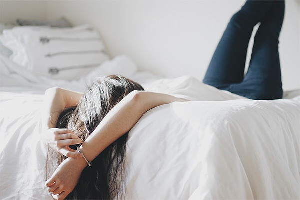 woman laying on bed with long hair